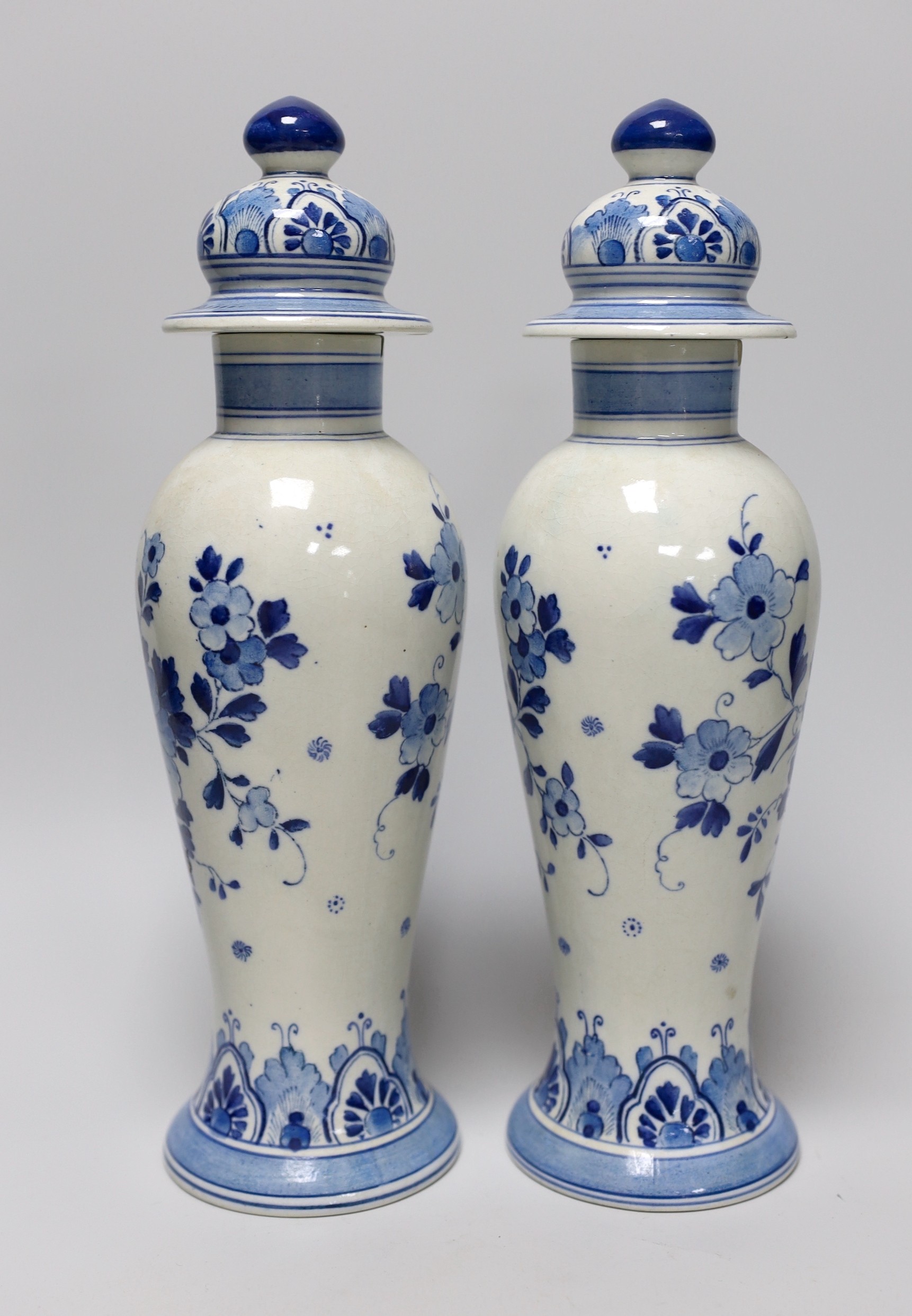 A pair of blue and white Delft vases and covers, 28cm